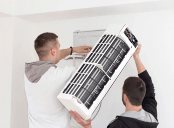 two young men are installing an air conditioner